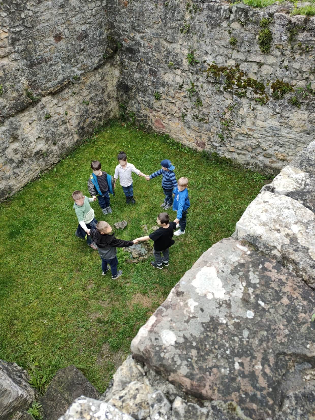 Kinder stehen in der ehemaligen Handmühle im Kreis.